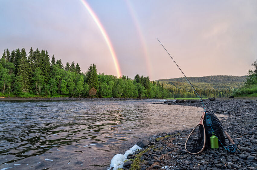 Fishing Gear Resting Near Lake With a Rainbow