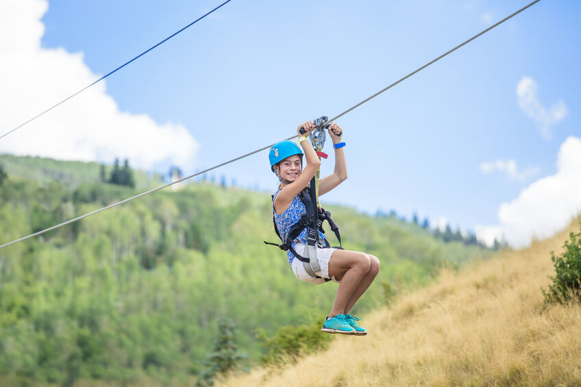 Young girl having fun zip lining